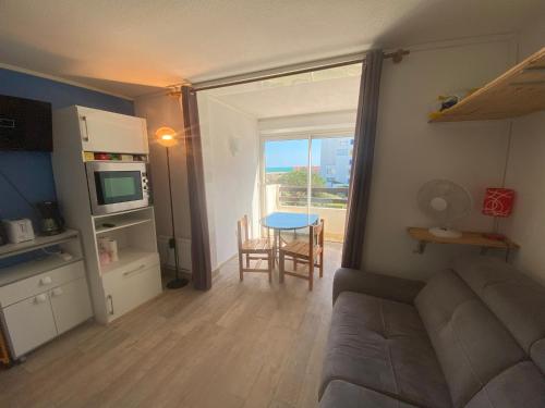 una sala de estar con un sofá y una mesa en Studio Vue Mer Le Barcarès, en Le Barcarès