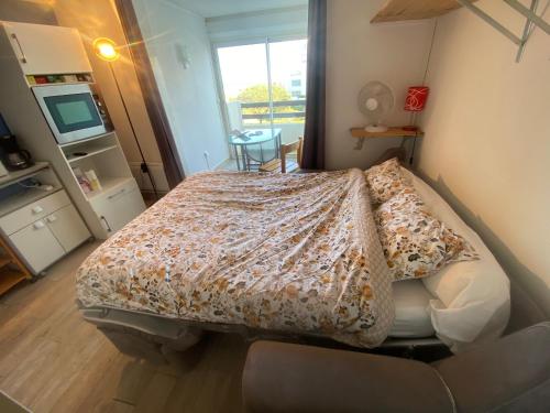 une chambre avec un lit avec une couverture dessus dans l'établissement Studio Vue Mer Le Barcarès, au Barcarès