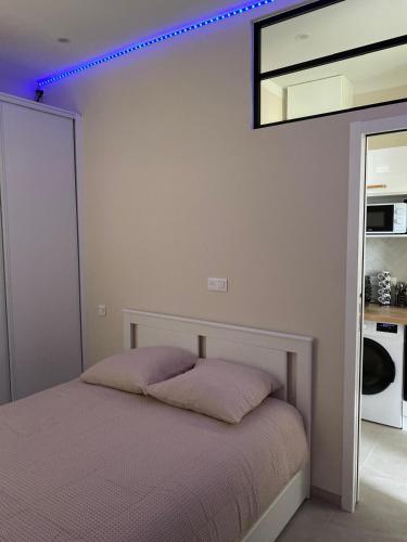 une chambre avec un lit et un miroir au mur dans l'établissement Charmant appartement T2, à Toulon