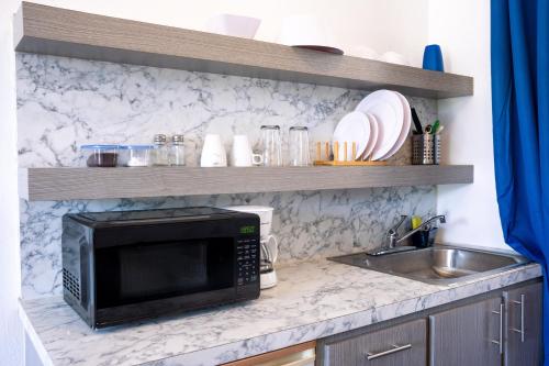 a kitchen counter with a microwave and a sink at Ocean Village at Combate in Cabo Rojo