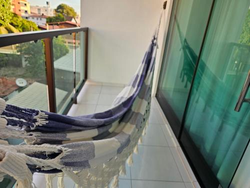 a hammock hanging on the side of a balcony at Pousada Asahi in Porto De Galinhas