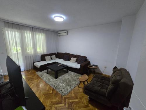 Marina G apartment في بريشتيني: غرفة معيشة بها أريكة وطاولة