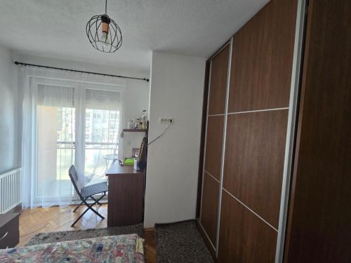 Marina G apartment في بريشتيني: غرفة نوم بها سرير ومكتب وباب