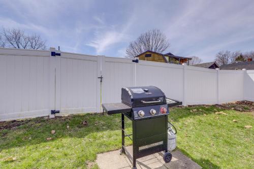 a grill in a yard next to a fence at Walk to OOB Pier Family-Friendly Home with Hot Tub! in Old Orchard Beach