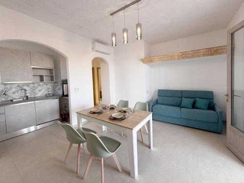 Una sala de estar con una mesa y un sofá azul. en Villa Virò by salentoltremare, en Alessano