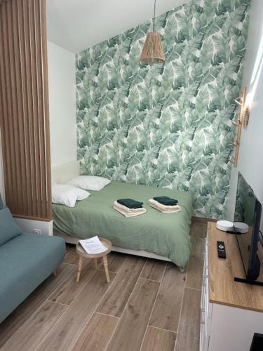 Cette chambre comprend un lit et un mur vert. dans l'établissement Studio 36, à Saint-Romain-de-Jalionas