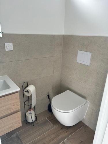 une salle de bain avec des toilettes blanches et un lavabo dans l'établissement Studio 36, à Saint-Romain-de-Jalionas