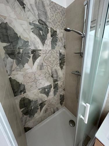 une douche avec une porte vitrée dans une salle de bain dans l'établissement Studio 36, à Saint-Romain-de-Jalionas