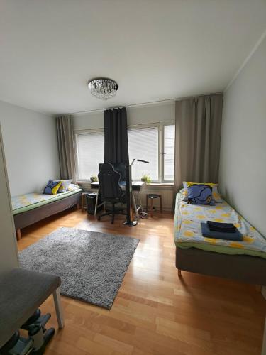 a bedroom with two beds and a desk in it at Spacious and bright 2 bedroom apartment in Oulu