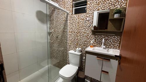 a bathroom with a toilet and a sink and a shower at 4 quartos, sendo 2 suítes - uma com varanda privativa, a 700m da Praia da Boca da Barra e 2,5km da orla de Tamandaré, Wifi 200MB e cozinha completa - Piscina e estacionamento privativos - Ideal para grupos e famílias - tranquilo para home office in Tamandaré