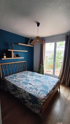 une chambre avec un lit avec un mur bleu dans l'établissement Maison vue mer, à Carqueiranne