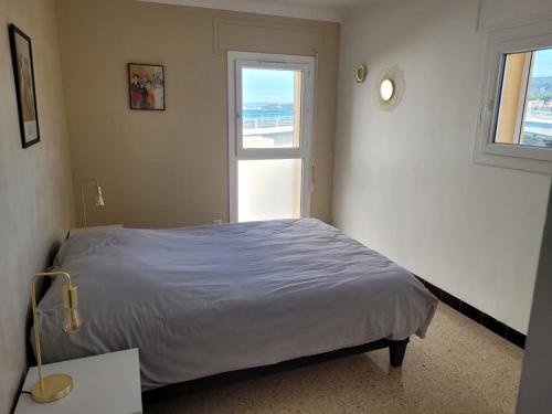 une chambre avec un lit et une fenêtre dans l'établissement Très beau T3 centre historique, à Martigues