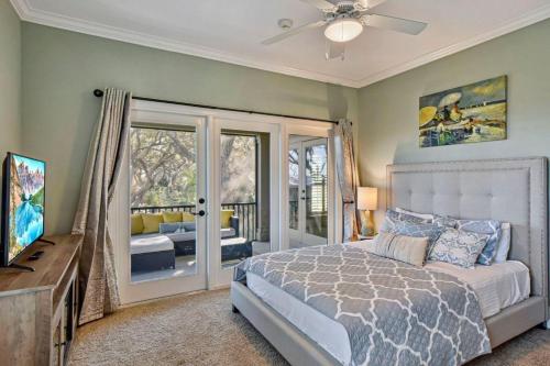 ein Schlafzimmer mit einem Bett und einer Glasschiebetür in der Unterkunft Garden Cottage 07 in Jekyll Island