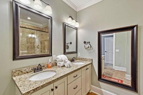 ein Badezimmer mit zwei Waschbecken und zwei Spiegeln in der Unterkunft Garden Cottage 07 in Jekyll Island