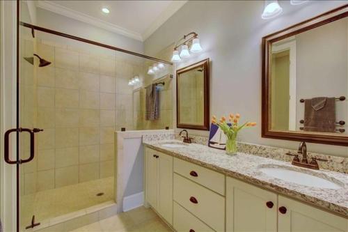 a white bathroom with two sinks and a shower at Garden Cottage 09 in Jekyll Island