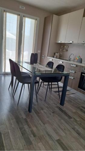a glass table and chairs in a kitchen at Home Suites Home in Salionze
