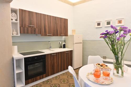 a kitchen with a table with a vase of purple flowers at Dimora S.Vito in Lequile