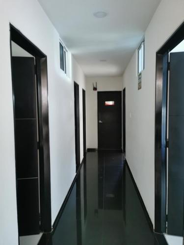 a hallway with black doors and white walls at hotel royal fenix in Yopal