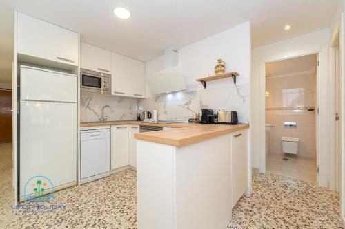 eine Küche mit weißen Schränken und einer Arbeitsplatte in der Unterkunft 2 bed 2 bath Magnus Apartment in El Campello