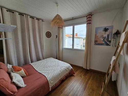 une chambre avec un lit et une fenêtre dans l'établissement Maison de location hypercentre, à La Tranche-sur-Mer