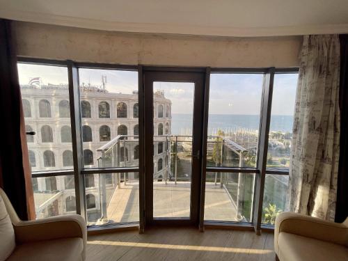 a room with large windows with a view of a building at Orbi Eva Aparatments in Batumi
