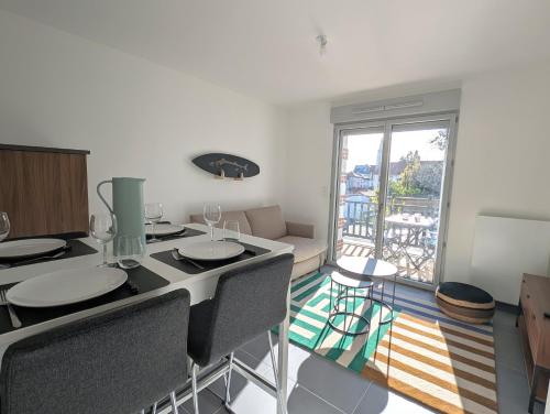 Cette chambre dispose d'une table, de chaises et d'un balcon. dans l'établissement Appartement lumineux avec balcon & aperçu mer, à Pornic