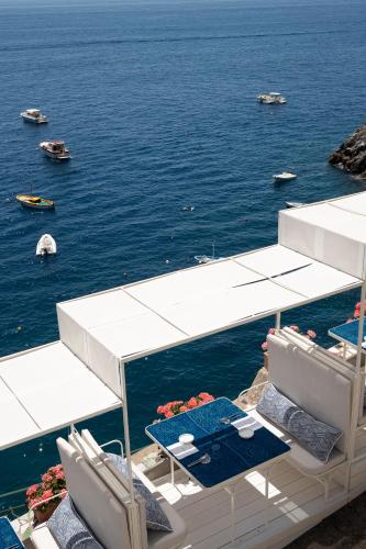 a table and chairs sitting on the deck of a boat at Hotel Onda Verde in Praiano