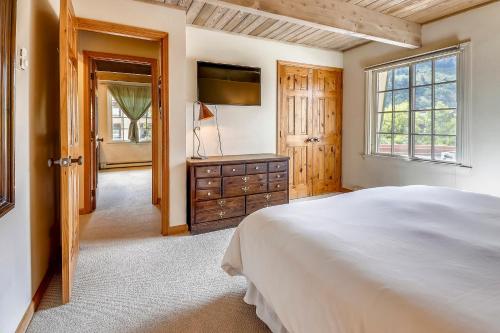 ein Schlafzimmer mit einem Bett und einem Fernseher und einem Fenster in der Unterkunft Top-Floor Condo Downtown with Stunning Views in Aspen