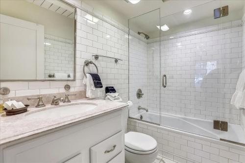 a white bathroom with a sink and a toilet and a tub at Walk Everywhere! Deluxe Aspen Condo in Aspen