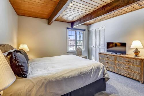 a bedroom with a large bed and a television at Modern Condo, 1 Block to Gondola - Ideal Vacation Location in Aspen