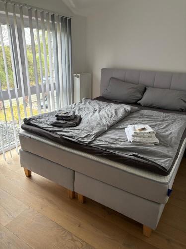 a bed in a bedroom with a mattressvisorvisor at Wood&Stone - Modernes Haus in Seenähe am Tankumsee mit Terrasse, Outdoorküche, Kamin, Homeoffice Bereich & voll ausgestatteter Küche im Naherholungsgebiet in Isenbüttel