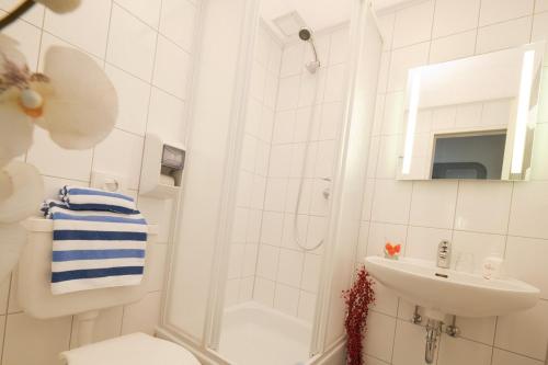 uma casa de banho com um chuveiro, um WC e um lavatório. em Hotel Cockpit em Hamburgo