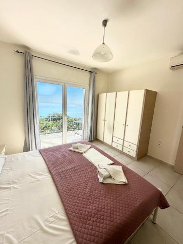 a bedroom with a large bed with a large window at Villa Georgia in Lourdata