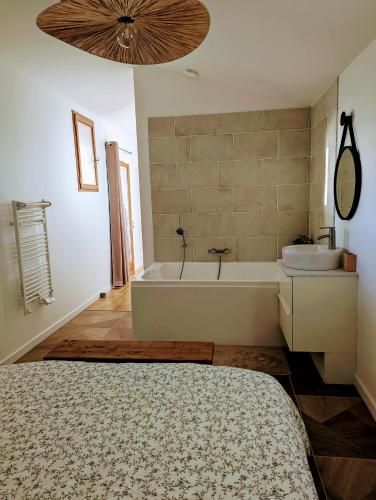 a bathroom with a bath tub and a sink at Dépendance avec balnéothérapie in Maurens