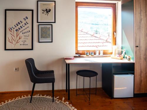 a desk in a room with two chairs and a window at Andar`s people in Sarajevo