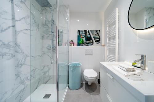 une salle de bain blanche avec douche et toilettes dans l'établissement Studio Vue mer Parking Clim, à Nice