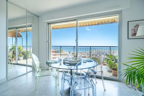 une salle à manger avec une table et des chaises en verre dans l'établissement Studio Vue mer Parking Clim, à Nice