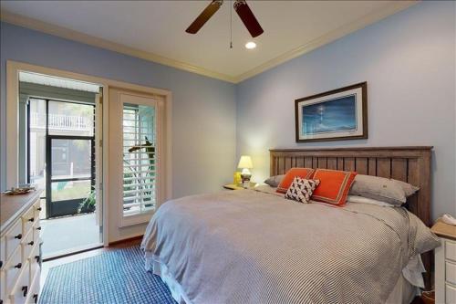 a bedroom with a large bed and a window at Garden Cottage 23 in Jekyll Island