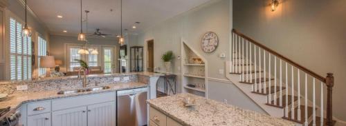 a large kitchen with a sink and a staircase at Poolside Cottage 32 in Jekyll Island