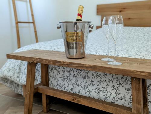 a table with a bottle of champagne and two glasses at Dépendance avec balnéothérapie in Maurens
