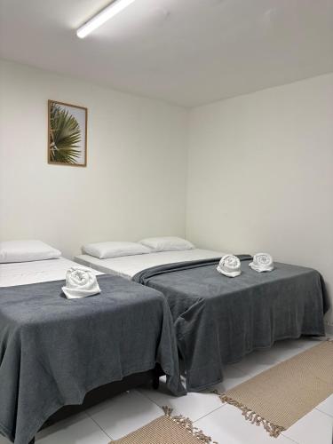 two beds in a room with tables with plates on them at Hotel Paraiso Natal - EXPRESS in Natal