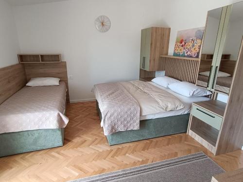 a bedroom with two beds and a mirror at Diana Rooms and Apartments in Starigrad-Paklenica