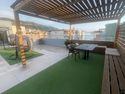 a patio with a table and chairs on a balcony at Luxury Rooftop Vlora in Vlorë