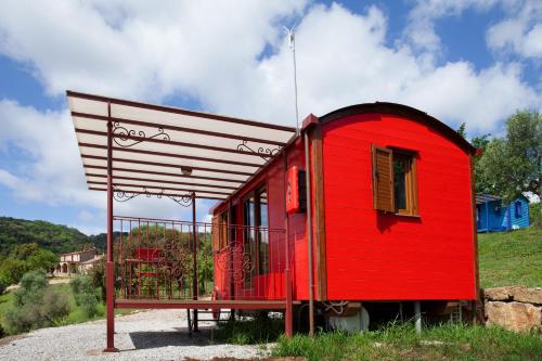 a red tiny house sitting on top of a hill at Poggio Diavolino - Suvereto in Suvereto