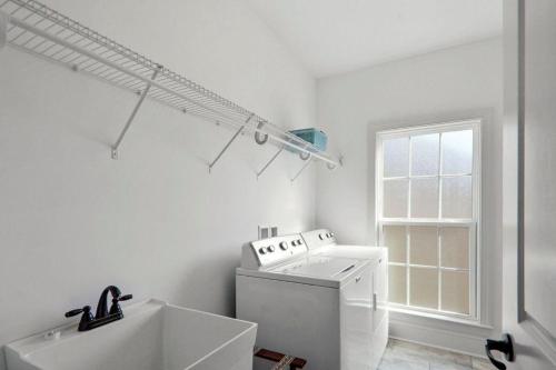 a white laundry room with a washer and dryer at Ocean Cottage 44 in Jekyll Island