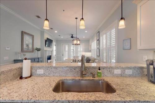 a kitchen with a sink and a living room at Poolside Cottage 57 in Jekyll Island