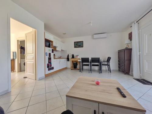 un salon avec une table et une cuisine dans l'établissement Les Jardins de Montéglin - F2 avec jardin, à Montéglin