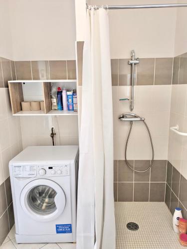 La salle de bains est pourvue d'un lave-linge et d'une douche. dans l'établissement Les Jardins de Montéglin - F2 avec jardin, à Montéglin