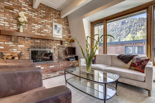 a living room with a couch and a fireplace at Lovely Aspen Condo with Mountain Views & Hot Tub in Aspen