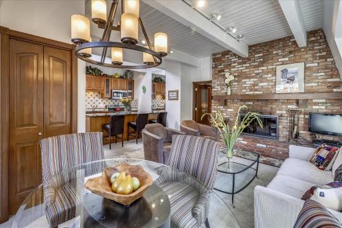 a living room with a table with a bowl of fruit on it at Lovely Aspen Condo with Mountain Views & Hot Tub in Aspen